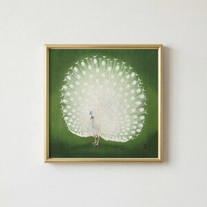 May include: A framed artwork featuring a white peacock with a fully fanned tail against a green background. The peacock has a blue crest and red legs. The artwork is in a gold frame.