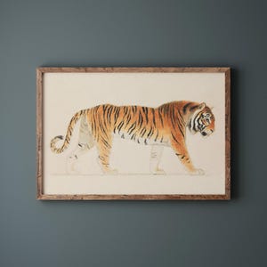 May include: Watercolor print of a tiger in a wooden frame. The tiger is depicted in profile, with orange and black stripes. The artwork is set against a cream-colored background.