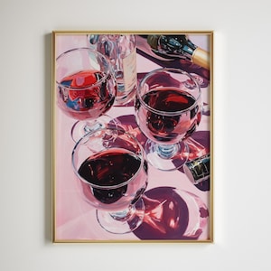 May include: A framed artwork featuring a still life of wine glasses filled with red wine. The painting includes wine bottles and their reflections on a pink surface. The artwork is enclosed in a gold frame.