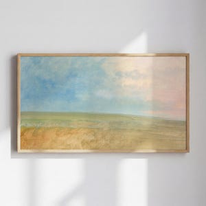 May include: A framed landscape painting with a serene scene of a field under a blue and pink sky. The artwork features a wooden frame and soft brushstrokes, creating a calming and natural aesthetic. The color palette includes shades of blue, yellow, and pink.