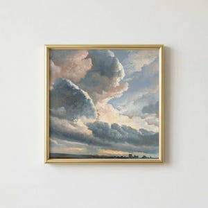May include: A framed painting of a dramatic cloudscape. The artwork features large, billowing clouds in shades of blue, gray, and peach, with a hint of golden light breaking through. The painting is set in a gold frame.