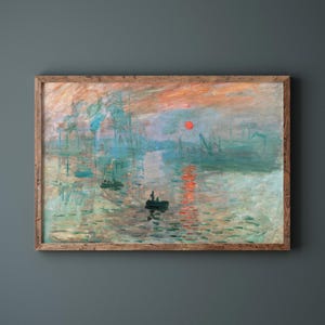 May include: A framed print of an impressionist painting showing a harbour scene at sunset. The artwork features a vibrant orange and red sky, with the sun reflected in the water. Boats and industrial structures are visible.