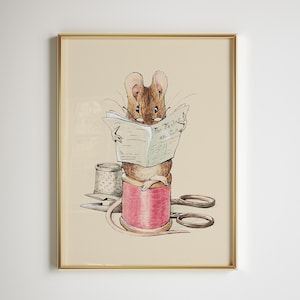 Puede incluir: Impresión enmarcada de un ratón marrón leyendo el periódico "The Tailor and Cutter". El ratón está posado sobre una bobina de hilo rosa, con un dedal y unas tijeras. La obra de arte tiene una estética vintage, de cuento.