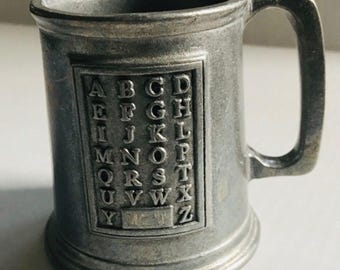 Taza de peltre vintage con alfabeto