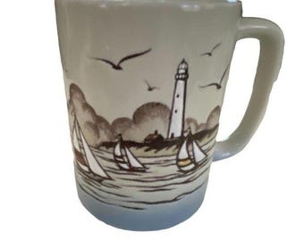Taza vintage de Otagiri con faro, velero y gaviota en la playa costera.