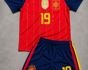 Peut inclure: Un maillot de football rouge avec de fines rayures verticales jaunes, des manches bleu marine et le numéro 19 en jaune. Il présente un écusson FIFA, un emblème d'équipe et un écusson Football Unites. Le short bleu marine assorti porte le 19.