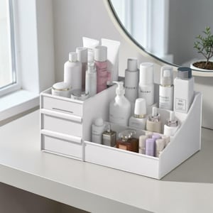 Op de afbeelding: Een set van drie keramische mokken met een gespikkelde, matte afwerking. De mokken zijn in tinten crème, lichtgrijs en donkergrijs. Elke mok heeft een eenvoudig, minimalistisch ontwerp.