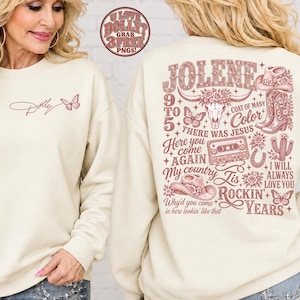 May include: A cream-colored crewneck sweatshirt featuring a small script logo and butterfly on the front. The back displays a large, detailed graphic in dusty rose ink, including text like JOLENE, 9 TO 5, and various western-themed illustrations.
