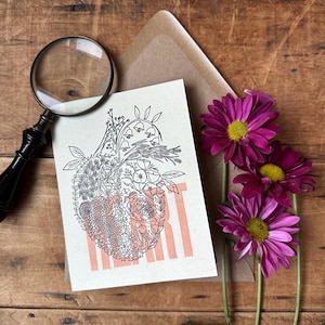 May include: A white card with a black and white illustration of a heart made of flowers. The word "HEART" is printed in pink below the illustration.