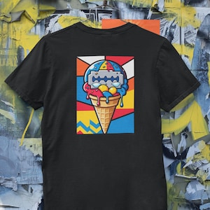 May include: Black t-shirt featuring a colorful graphic of an ice cream cone with a razor blade on top. The ice cream has red, yellow, and blue scoops, with a waffle cone base. The design is set against a geometric background.