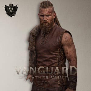 Op de afbeelding: Bruin leren vest met veters aan de zijkanten en een schouderstuk van bont. De afbeelding toont een outfit met een Viking-thema. De tekst "Vanguard Leather Vault" en een schildlogo zijn ook zichtbaar.