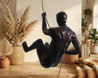 Skulptur av klättrare, dekor av bergsklättrare, modern abstrakt skulptur, väggklättringsstaty