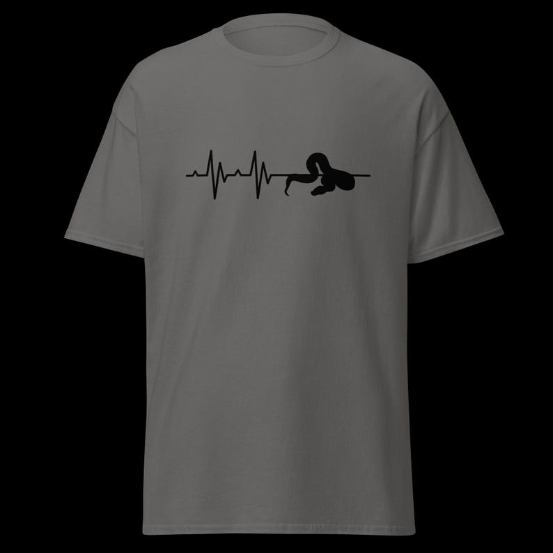 May include: Grey t-shirt with a black graphic depicting a heartbeat line morphing into a snake silhouette. The design is centrally placed. The shirt has short sleeves and a crew neck.