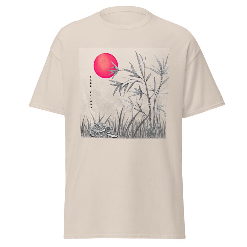 Może przedstawiać: Beżowa koszulka z grafiką przedstawiającą czerwone słońce, bambus i węża na polu. Tekst "BALL PYTHON" jest wydrukowany pionowo. Koszulka ma kr&oacute;tkie rękawy i okrągły dekolt. Projekt jest w odcieniach szarości i beżu.