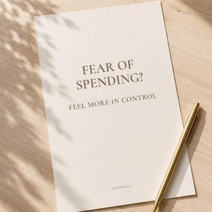 Puede incluir: Una hoja de papel rectangular de color blanco roto con el texto oscuro FEAR OF SPENDING? FEEL MORE IN CONTROL y la marca MAISONELLA en la parte inferior, acompañada de un bolígrafo de metal dorado sobre el lado derecho del papel.