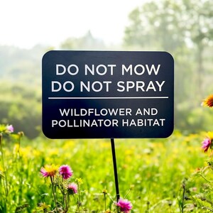 Black aluminum sign staked in a vibrant wildflower field, reading 'Do Not Mow, Do Not Spray – Wildflower and Pollinator Habitat.' The engraved plaque stands out against a colorful natural background filled with yellow, purple, and pink blooms, emphasizing its role in protecting eco-friendly garden spaces and supporting pollinator conservation efforts. Ideal for sustainable landscaping, this durable, USA-made sign offers long-term outdoor visibility and clarity.
