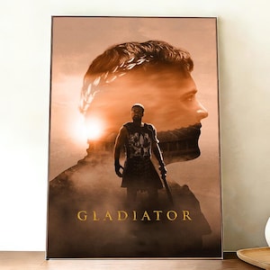 Könnte beinhalten: Gerahmter Druck mit einem Sepia-Ton-Bild eines Gladiators. Das Wort "GLADIATOR" steht in goldfarbenen Buchstaben am unteren Rand. Das Bild zeigt eine Doppelbelichtung mit dem Profil eines Mannes mit Lorbeerkranz im Hintergrund.