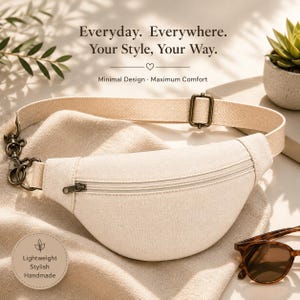 Puede incluir: Una riñonera de lona color crema con un bolsillo frontal con cremallera, una correa ajustable de tela beige y herrajes de metal en tono latón antiguo. El texto dice: Everyday. Everywhere. Your Style, Your Way. Minimal Design. Maximum Comfort.