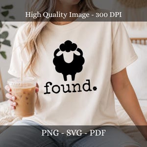 May include: A cream-colored short-sleeve t-shirt featuring a black graphic of a stylized sheep silhouette centered on the chest. Below the sheep, the word found is printed in a black, distressed, lowercase serif font with a period at the end.