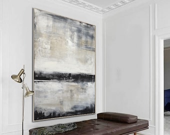 May include: Large abstract painting with a neutral color palette of black, white, and beige. The artwork is framed and hangs above a brown leather chaise lounge. A silver floor lamp and a patterned throw blanket are also in the room.