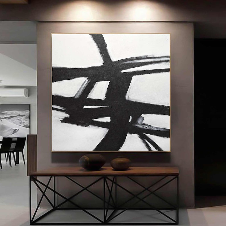 May include: Abstract black and white painting with bold brushstrokes on a white canvas. The painting features a series of intersecting lines and shapes, creating a dynamic and modern design.