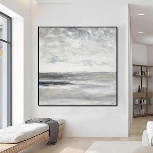 May include: Abstract painting with a gray and white color scheme. The painting depicts a landscape with a horizon line and clouds. The painting is framed in black.