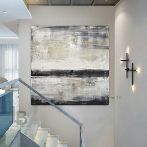 May include: Large abstract painting in neutral tones of gray, black, and beige. The artwork is displayed on a white wall above a staircase with a glass railing. The painting has a textured appearance and is signed by "Belboer Fine Art".