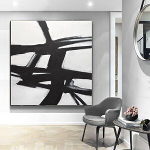 May include: Black and white abstract painting with bold brushstrokes on a white canvas. The painting features a series of intersecting lines and shapes, creating a dynamic and modern design.