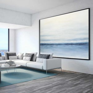 May include: A white sectional sofa with gray throw pillows in a modern living room with a large abstract painting of a blue and white seascape hanging on the wall.