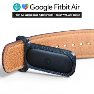 Puede incluir: Adaptador de correa de reloj Fitbit Air negro con una correa de reloj de cuero marrón. El adaptador tiene el logotipo de Google y el texto "Fitbit Air Watch Band Adapter Slim - Wear With Any Watch".