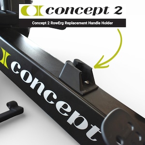 Op de afbeelding: Een zwarte Concept 2 RowErg vervangende handgreep houder. De houder is gemonteerd op een zwart frame met het Concept 2 logo in wit en geel. De tekst "Concept 2 RowErg Replacement Handle Holder" is ook zichtbaar.