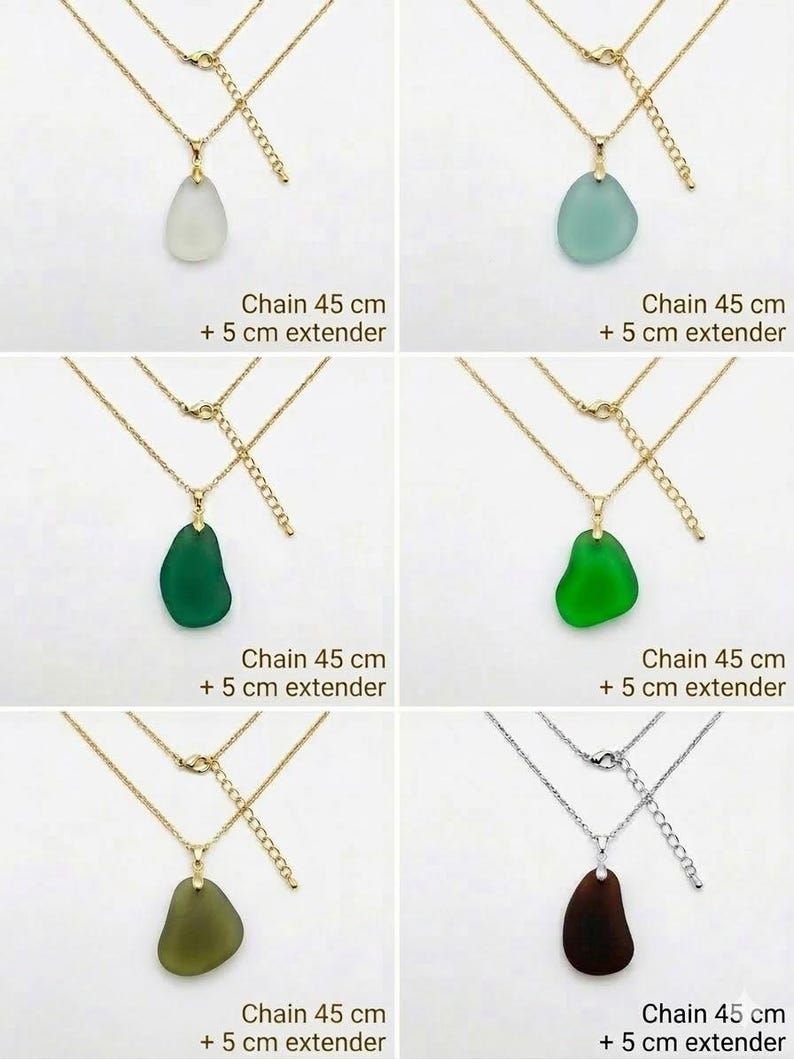 May include: A collection of necklaces with pendants in various colors, including white, teal, green, and brown. Each necklace features a gold-colored chain with a 45 cm length and a 5 cm extender. The pendants have a smooth, organic shape.