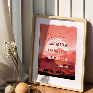 Puede incluir: Impresión artística enmarcada con un paisaje desértico en tonos cálidos y el texto "HAVE NO FEAR! I AM WITH YOU, I HEAR AND I SEE. QURAN 20:46." El marco es de madera clara, sobre una superficie de madera.