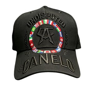 May include: Black baseball cap with the word "UNDISPUTED" arched across the top. The front features a circular emblem with flags and the letters "AA". The word "CANELO" is embroidered on the bill.