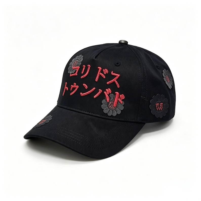 May include: Black baseball cap with red Japanese text and flower patches. The cap has embroidered text and several flower-shaped patches in grey and red. A stylish accessory for casual wear.