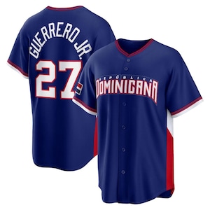 May include: A navy blue baseball jersey with white and red detailing. The back features "GUERRERO JR." above the number "27" in white. The front displays "REPÚBLICA DOMINICANA" in white. The jersey has a button-up front and short sleeves.