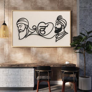 Peut inclure: Une décoration murale rectangulaire présentant un dessin au trait noir sur fond crème. L'œuvre représente deux personnages portant des turbans, reliés par une forme de cœur centrale contenant le symbole Ik Onkar en lettres cursives noires.