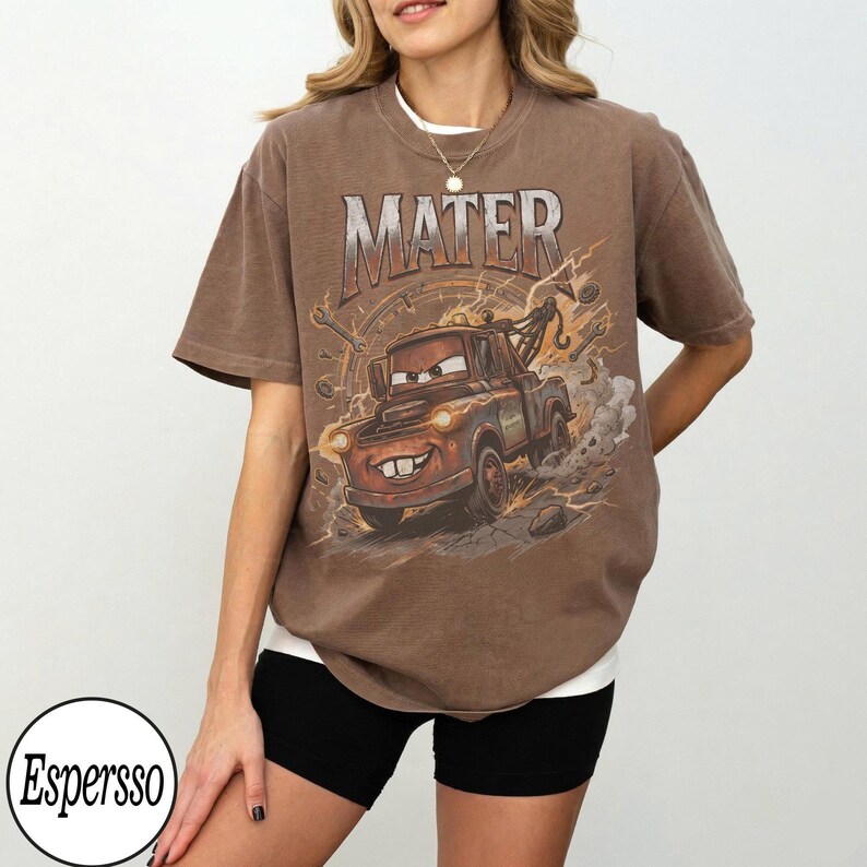 May include: Brown t-shirt featuring a graphic of Mater from the movie Cars. The design includes the word "MATER" in a distressed font, a cartoon image of Mater, and lightning bolts. The shirt is a relaxed fit.