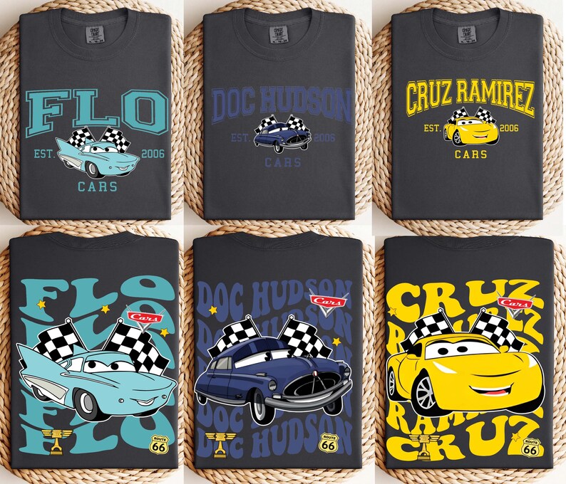 以下が含まれることがあります： 車をテーマにしたグラフィックが施された、濃いグレーのTシャツ6枚。デザインには「FLO」、「DOC HUDSON」、「CRUZ RAMIREZ」の名前が使われており、それぞれに漫画の車と「CARS」の文字が添えられています。シャツには「2006」の年も表示されています。