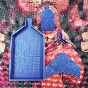 May include: A set of blue diamond painting accessories, including a tray, a funnel, and a tool. The tray has a textured surface. The accessories are designed for organizing and applying diamond art gems.