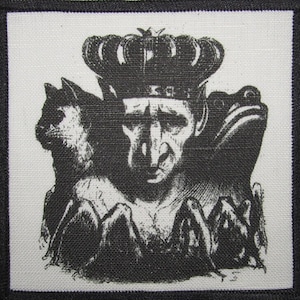 Peut inclure: Illustration en noir et blanc d'une figure couronnée avec un chat et une grenouille de chaque côté. La figure a une expression sérieuse et est entourée des animaux.