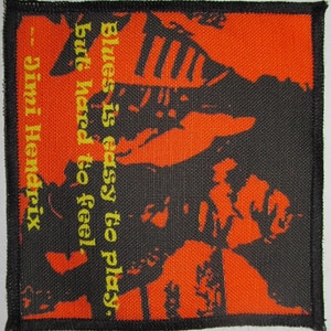 Op de afbeelding: Een zwart-wit afbeelding van Jimi Hendrix met een oranje achtergrond. De quote "Blues is easy to play, but hard to feel." staat in gele tekst onder de afbeelding. De quote wordt toegeschreven aan Jimi Hendrix.