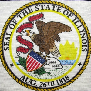 May include: The official seal of the State of Illinois features a bald eagle with outstretched wings holding a shield with 13 stars and red and white stripes. The eagle is perched on a rock with the words "National Union" and "State Sovereignty" on a scroll. The seal also includes a rising sun over a body of water and the date "Aug. 26th 1818".