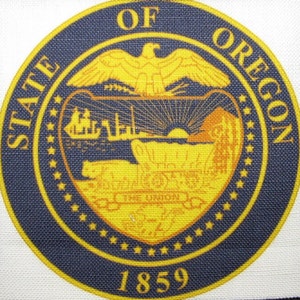 Puede incluir: Un sello azul y dorado con las palabras "State of Oregon" y el año "1859" alrededor del borde. El sello presenta un águila dorada con las alas extendidas sobre una cordillera y un río.