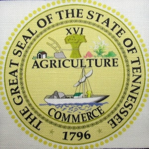 May include: The Great Seal of the State of Tennessee features a yellow background with a gold chain border. The seal depicts a ship sailing on a blue body of water with the words "Commerce" below. Above the ship, the words "Agriculture" are printed in black. The seal also includes a tree, a house, and a plow. The year "1796" is printed at the bottom of the seal.