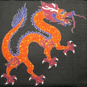 May include: A red and blue embroidered dragon with yellow accents on a black fabric background.
