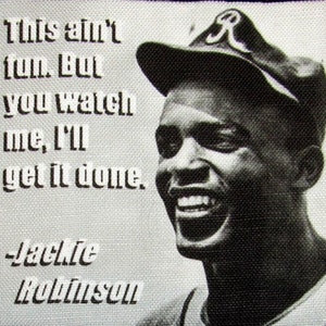 Puede incluir: Una foto en blanco y negro de un jugador de béisbol con una gorra de béisbol con una letra "A" en ella. La cita "This ain't fun. But you watch me, I'll get it done." está impresa sobre la cabeza del jugador. El nombre del jugador "Jackie Robinson" está impreso debajo de la cita.