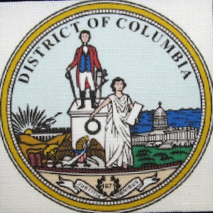 May include: A circular seal with the words "District of Columbia" around the edge. The seal features a white building with a woman standing on top of it, holding a scroll. A man in a red and blue uniform stands on the building, holding a sword. The seal also features a wreath of leaves and the year "1792".