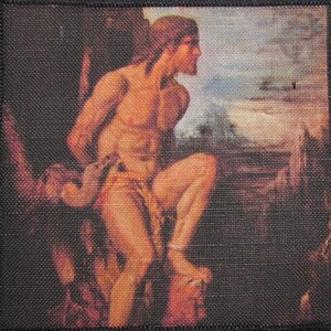 Puede incluir: Un parche bordado de estilo vintage que presenta una figura masculina desnuda con cabello largo, sentada en una roca y mirando hacia un paisaje distante. El parche está sobre un fondo marrón oscuro.