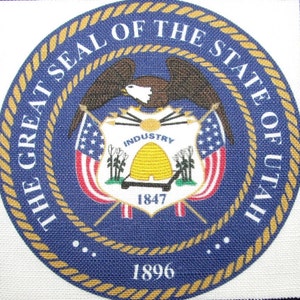 May include: The Great Seal of the State of Utah, a blue circle with a gold rope border, features a bald eagle with wings spread, a shield with a beehive and the words "Industry" and "1847", and two crossed flags. The text "The Great Seal of the State of Utah" is written around the top of the circle, and the year "1896" is written at the bottom.